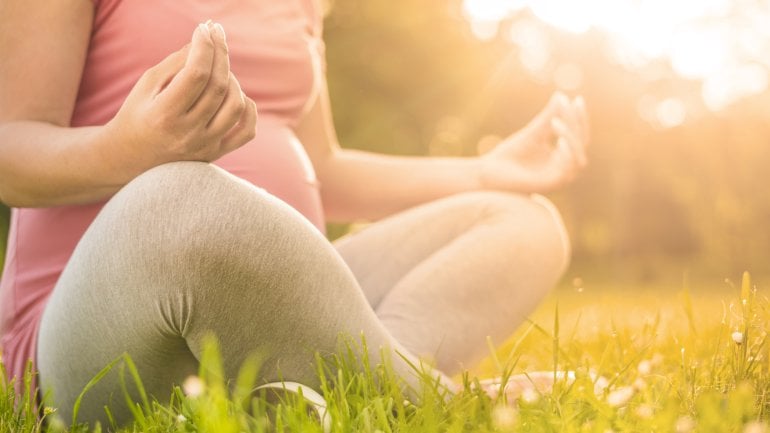 Eine Schwangere entspannt beim Yoga.