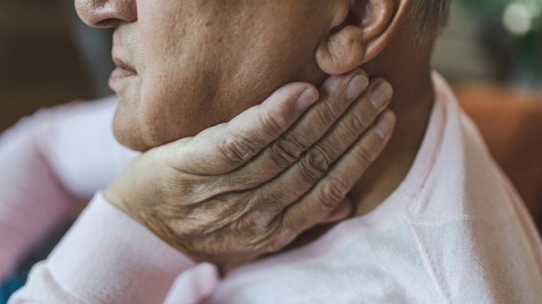 Älterer Mann hält sich die Hand an die geschwollene Ohrspeicheldrüse