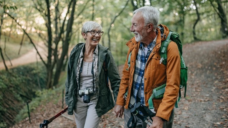 Älteres Pärchen geht gemeinsam wandern und ist trotz Arthrose aktiv.