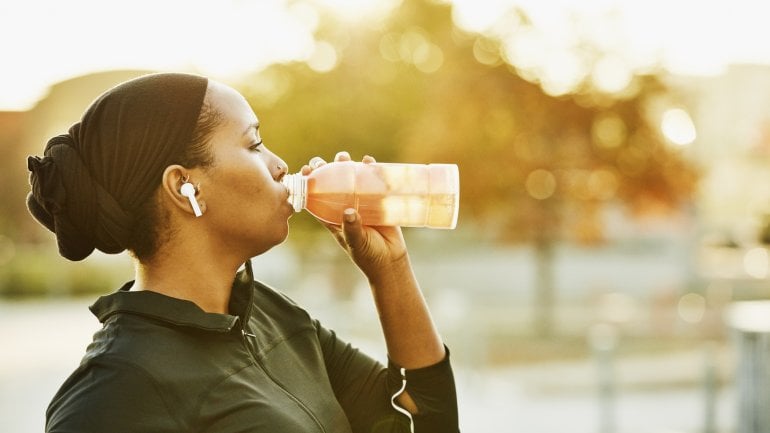 Frau trinkt Energy-Drink beim Sport.