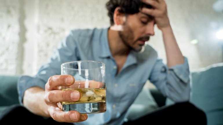 Ein Mann mit einem Glas hochprozentigem Alkohol