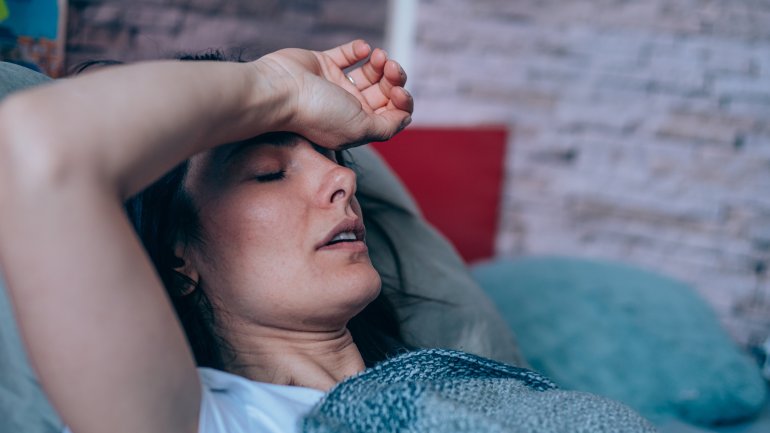 Frau mit Anämie liegt erschöpft im Bett.