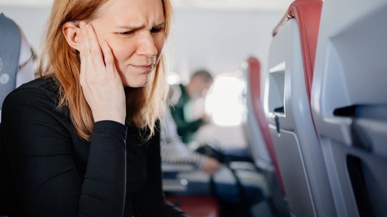 Frau erleidet Barotrauma beim Fliegen.