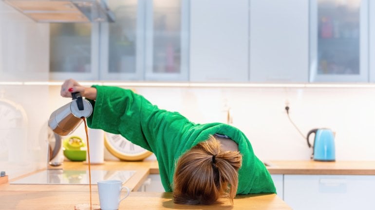 Müde Frau mit Kopf auf dem Tisch