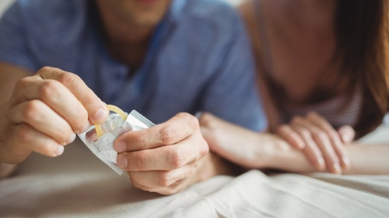 Ein Paar verwendet beim Geschlechtsverkehr ein Kondom.