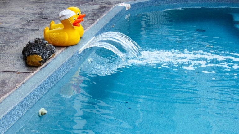 Zwei gelbe Badeenten am Rand eines Schwimmbads