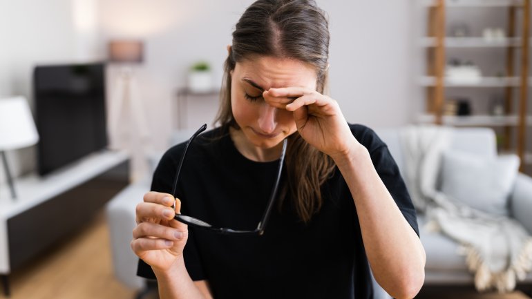 Frau mit Brille reibt sich die Augen