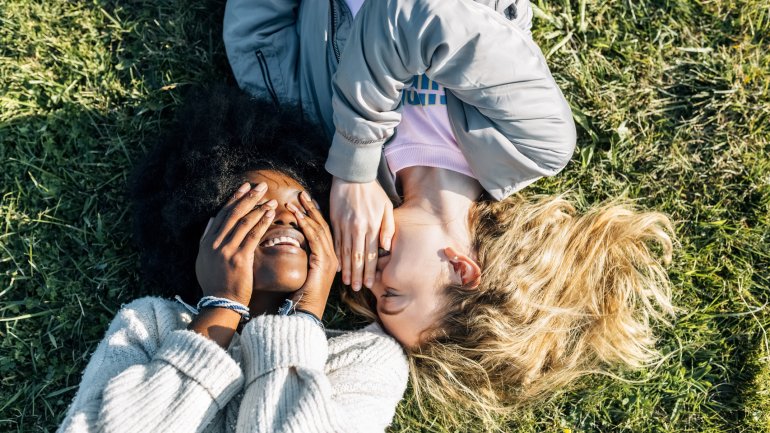 Defloration: Junge Freundinnen liegen auf einer Wiese.