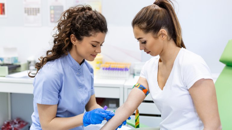 Einer jungen Frau wird Blut abgenommen