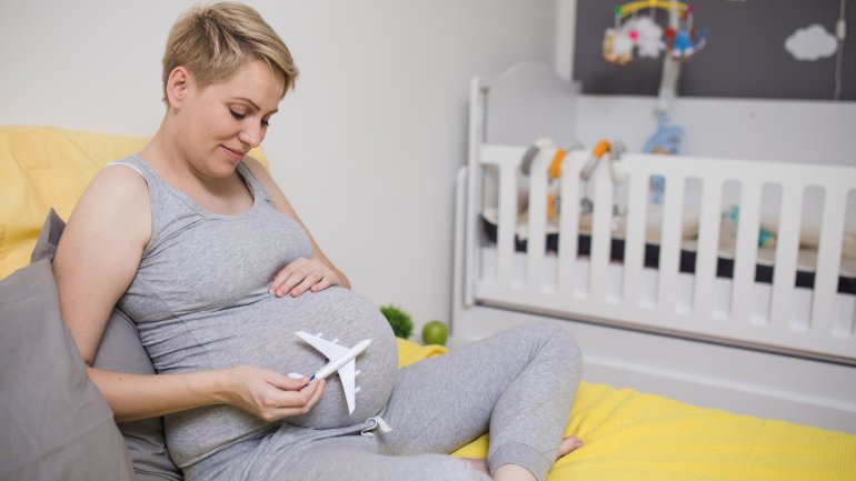 Schwangere Frau mit Modellflugzeug