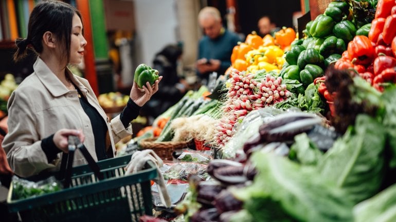 Frau kauft Gemüse für FODMAP-Diät bei Reizdarm ein.