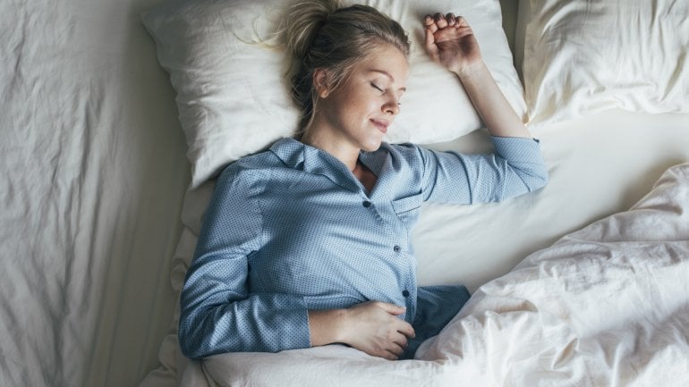 Eine Frau liegt im Bett und schläft.