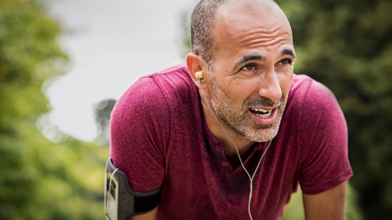 Ein verschwitzter Jogger macht eine Atempause.