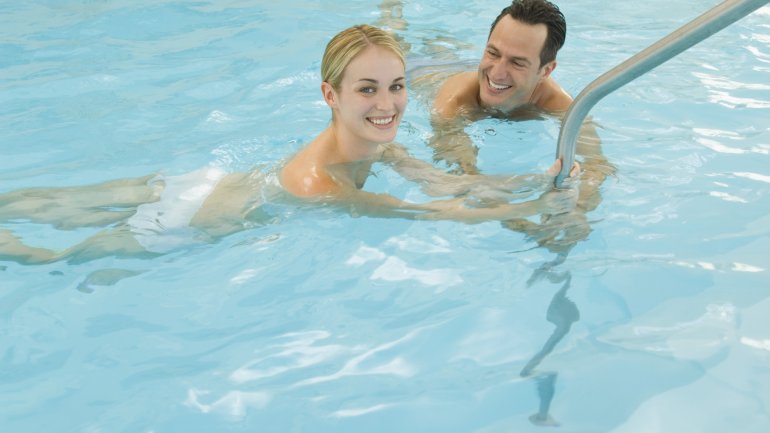 Das Bild zeigt ein Paar im Schwimmbecken.