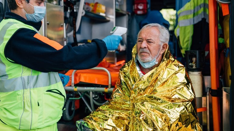 Mann mit Hypothermie wird durch eine Rettungsdecke aufgewärmt und notärztlich untersucht.