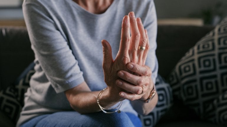 Frau mit Karpaltunnelsyndrom fasst sich ans Handgelenk.