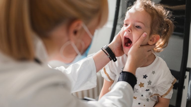 Mundfäule: Ärztin untersucht Kind