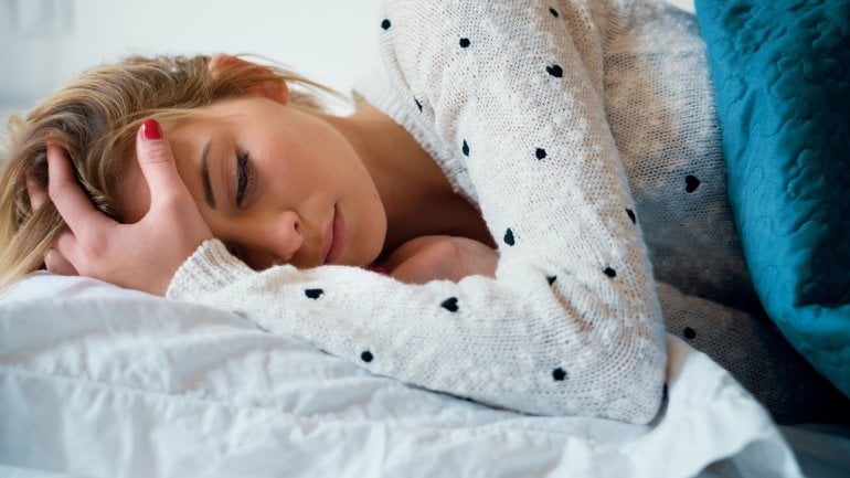 Junge Frau mit Fieber im Bett.