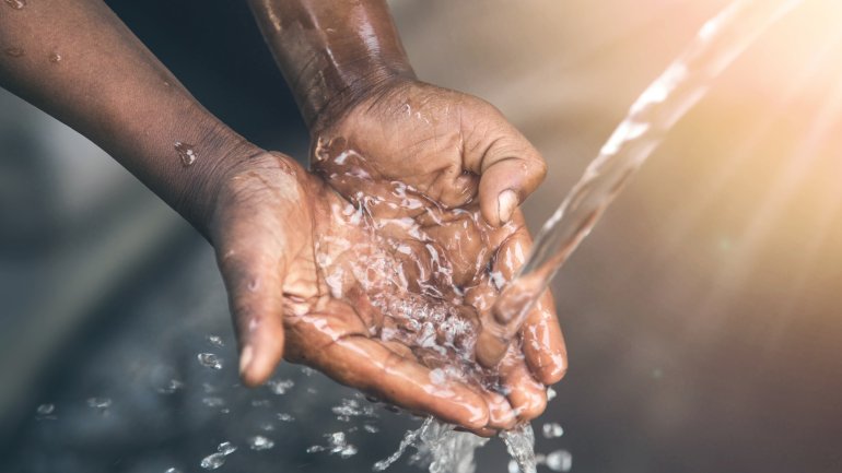 Hände fangen Trinkwasser aus einem Hahn auf